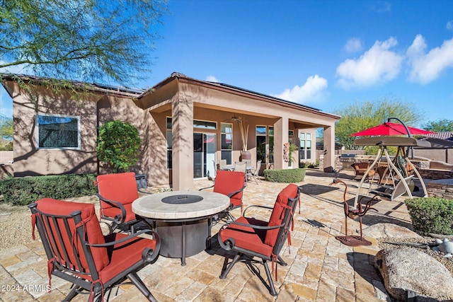 view of patio with ceiling fan and an outdoor fire pit