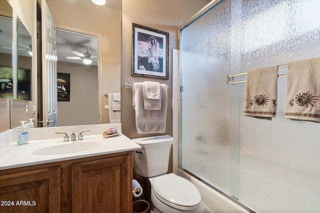 full bathroom featuring vanity, toilet, ceiling fan, and bath / shower combo with glass door