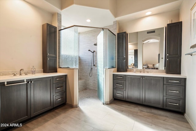 bathroom with a tile shower and vanity