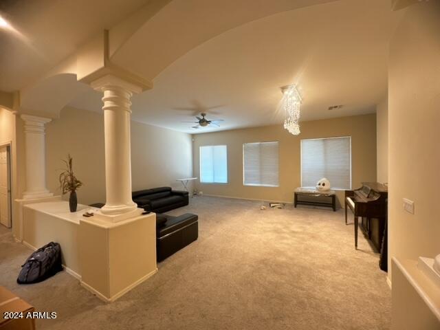 sitting room with light colored carpet, ceiling fan, and ornate columns