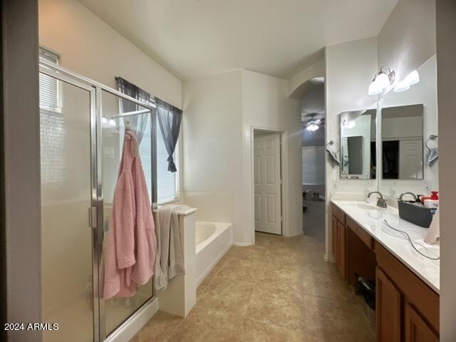 bathroom with vanity and shower with separate bathtub