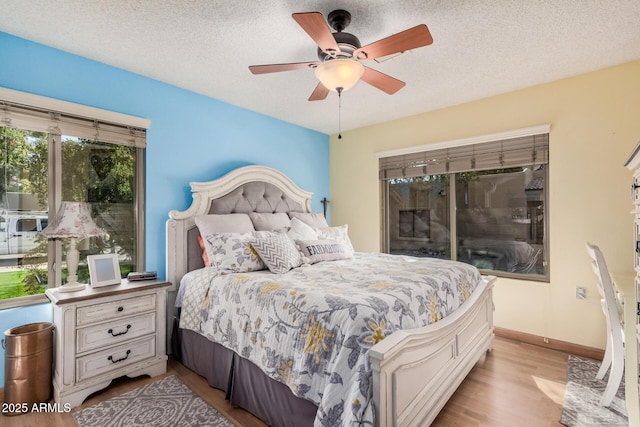 bedroom featuring light wood-style floors, ceiling fan, a textured ceiling, and baseboards