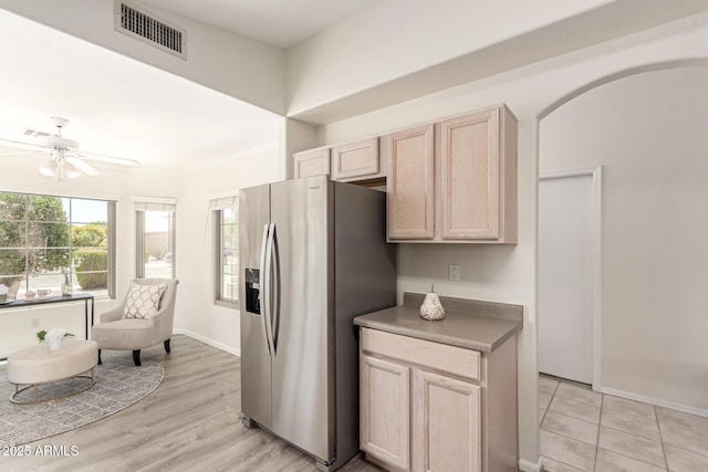 kitchen with stainless steel fridge with ice dispenser, light brown cabinetry, ceiling fan, baseboards, and ornamental molding