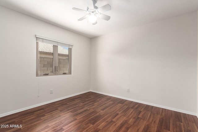 empty room featuring dark wood-style floors, baseboards, and ceiling fan