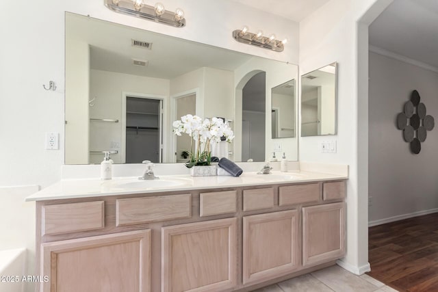 bathroom featuring double vanity and baseboards