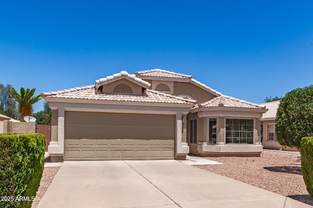 view of front of house with a garage, concrete driveway, stucco siding, and a tile roof