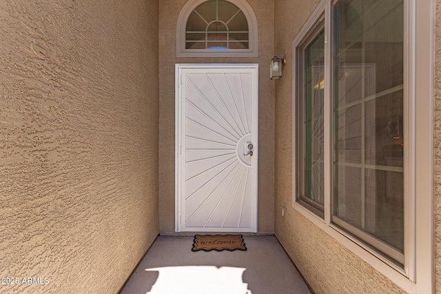 doorway to property featuring stucco siding