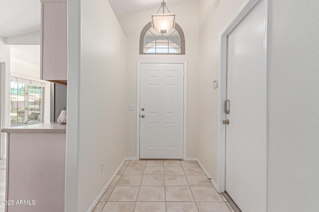 doorway featuring light tile patterned floors and baseboards