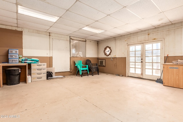 basement featuring a drop ceiling and french doors