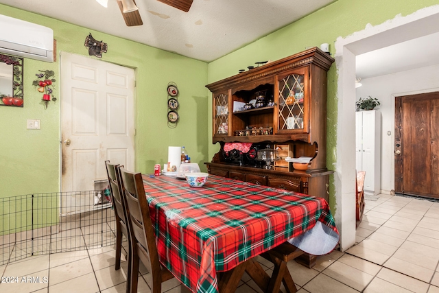 tiled dining room featuring a wall mounted air conditioner and ceiling fan