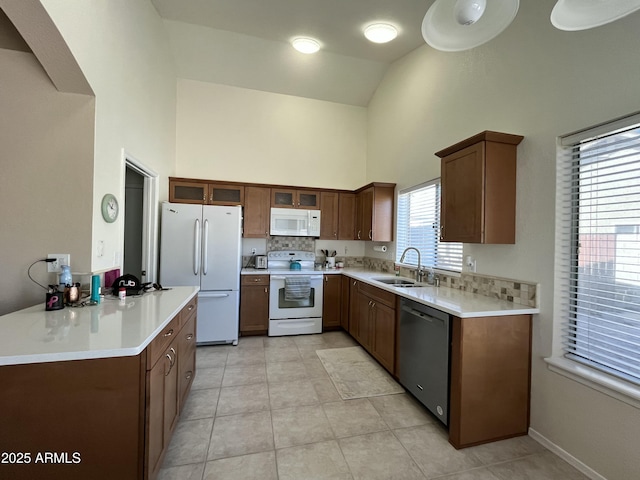 kitchen featuring light tile patterned flooring, white appliances, high vaulted ceiling, and sink