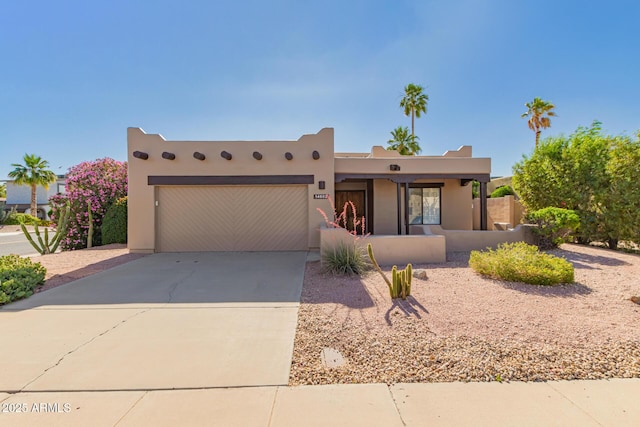 14602 N 63rd Pl, Scottsdale, AZ 85254 - pueblo-style home featuring a garage, driveway, and stucco siding