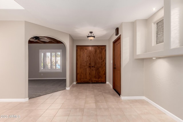 14602 N 63rd Pl, Scottsdale, AZ 85254 - entrance foyer featuring baseboards, a ceiling fan, light tile patterned flooring, light colored carpet, and arched walkways