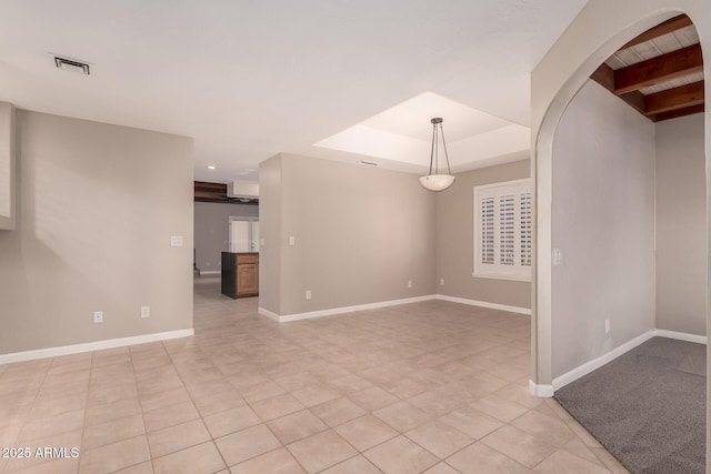 14602 N 63rd Pl, Scottsdale, AZ 85254 - empty room with light tile patterned flooring, beamed ceiling, arched walkways, a tray ceiling, and baseboards