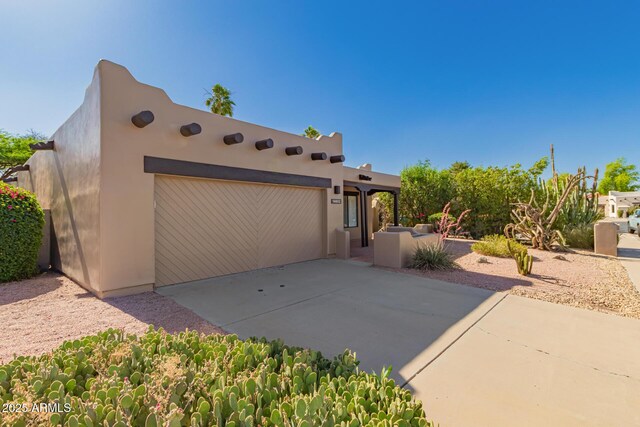 14602 N 63rd Pl, Scottsdale, AZ 85254 - view of front facade featuring concrete driveway, an attached garage, and stucco siding
