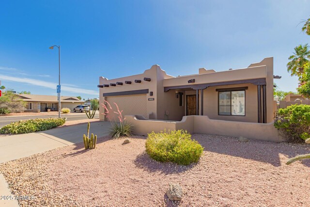 14602 N 63rd Pl, Scottsdale, AZ 85254 - adobe home featuring concrete driveway, an attached garage, and stucco siding