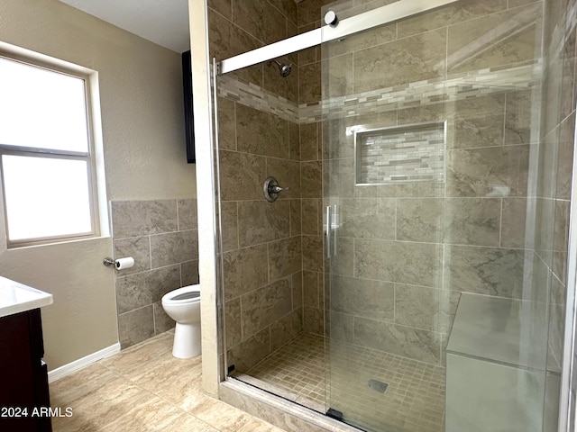 bathroom with vanity, toilet, plenty of natural light, and an enclosed shower