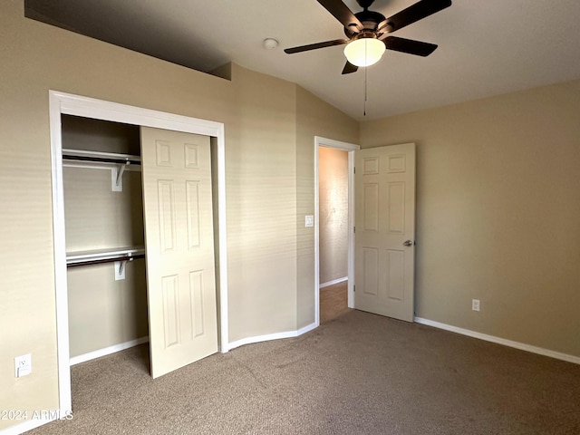 unfurnished bedroom with vaulted ceiling, carpet floors, a closet, and ceiling fan