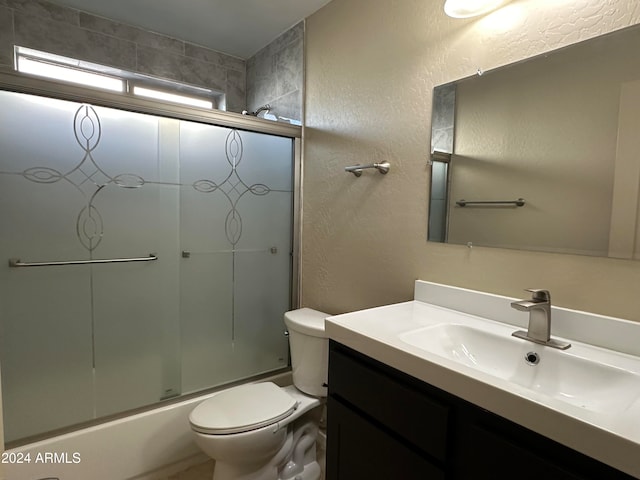 full bathroom with vanity, toilet, and shower / bath combination with glass door