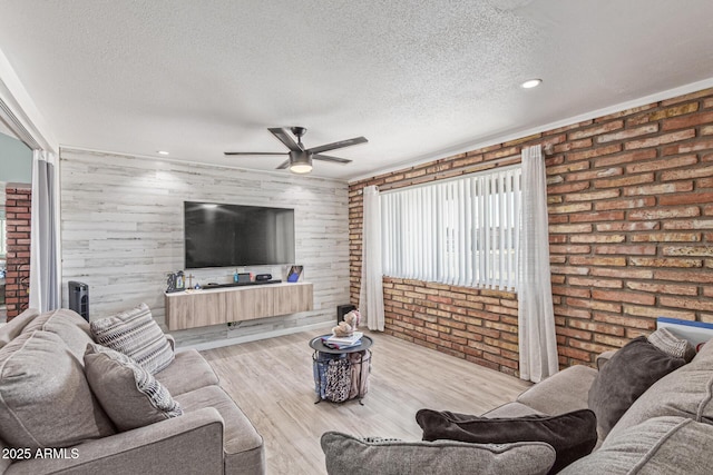 1235 E Dover St, Mesa, AZ 85203 - living room with a textured ceiling, ceiling fan, wood finished floors, brick wall, and recessed lighting