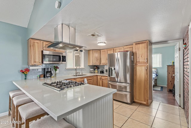 1235 E Dover St, Mesa, AZ 85203 - kitchen with stainless steel appliances, island exhaust hood, a sink, a breakfast bar, and a textured ceiling