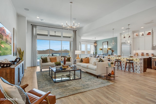 living room with light hardwood / wood-style flooring and an inviting chandelier