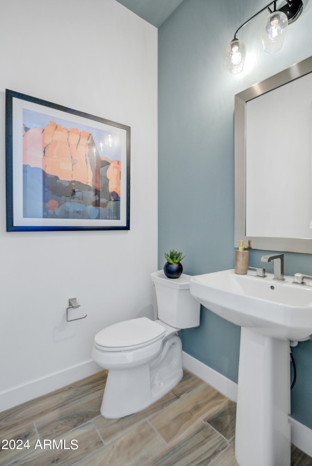 bathroom with toilet, sink, and hardwood / wood-style floors