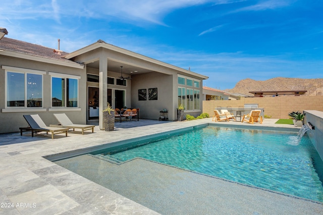 view of pool featuring pool water feature, ceiling fan, a patio, and an outdoor hangout area