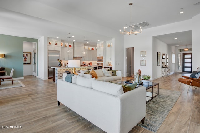 living room with light wood-type flooring and a chandelier