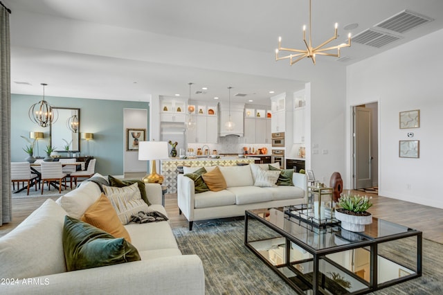 living room featuring hardwood / wood-style flooring, a chandelier, and sink