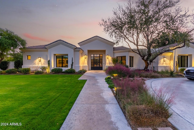 view of front of home with a yard and french doors