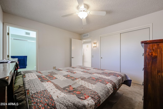 bedroom with a closet, light colored carpet, a textured ceiling, and ceiling fan