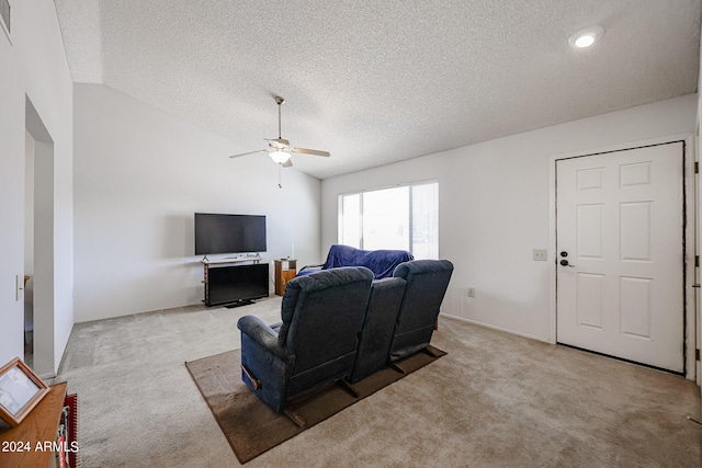 carpeted living room featuring ceiling fan, vaulted ceiling, and a textured ceiling