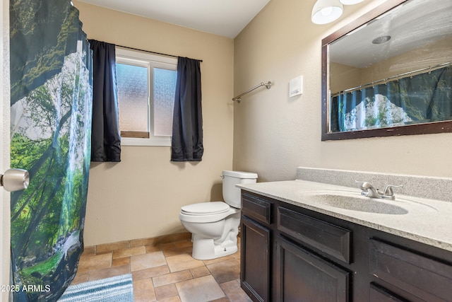 full bathroom with toilet, stone finish floor, vanity, and baseboards