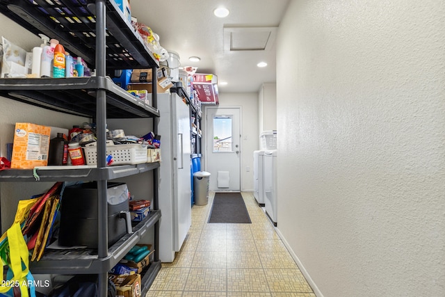 storage room with attic access and washer and dryer