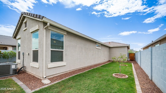 37820 W San Sisto Ave, Maricopa, AZ 85138 - view of property exterior featuring a lawn, a fenced backyard, central air condition unit, and stucco siding