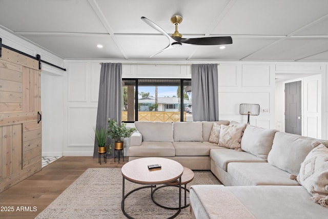 8214 E Northland Dr, Scottsdale, AZ 85251 - living area featuring coffered ceiling, wood finished floors, a barn door, a decorative wall, and a ceiling fan