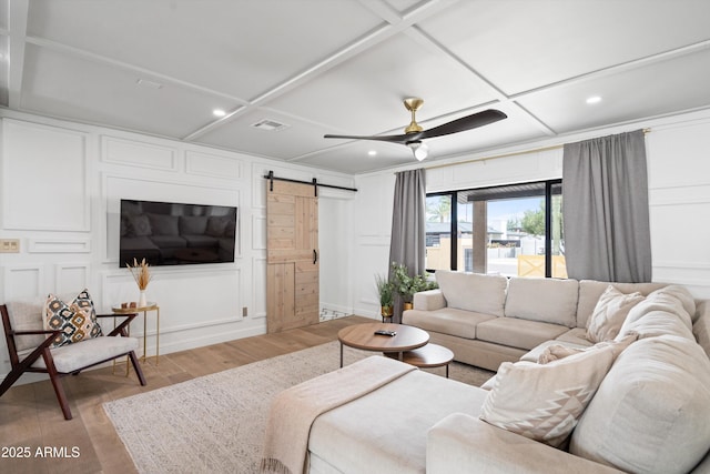 8214 E Northland Dr, Scottsdale, AZ 85251 - living room featuring a barn door, coffered ceiling, a decorative wall, recessed lighting, and light wood-style floors