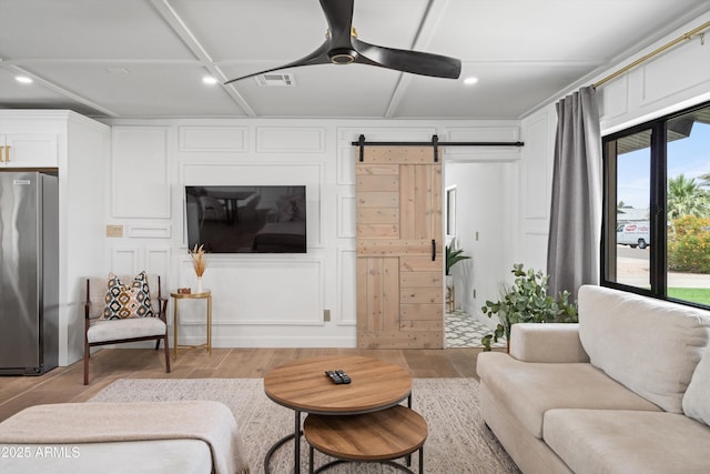 8214 E Northland Dr, Scottsdale, AZ 85251 - living area featuring light wood-style flooring, a barn door, recessed lighting, a decorative wall, and ceiling fan