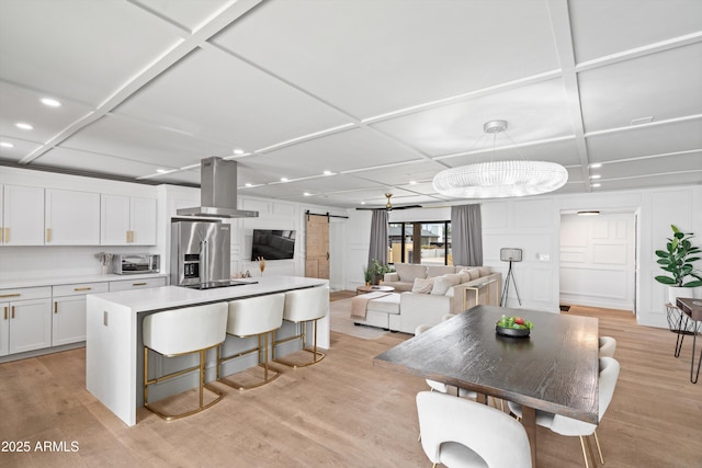 8214 E Northland Dr, Scottsdale, AZ 85251 - kitchen featuring high end fridge, coffered ceiling, island exhaust hood, a barn door, and recessed lighting