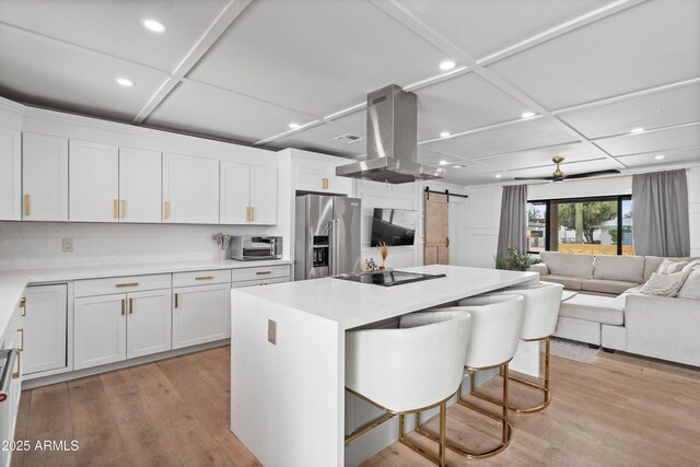 8214 E Northland Dr, Scottsdale, AZ 85251 - kitchen featuring high end refrigerator, island range hood, a barn door, a breakfast bar area, and black electric stovetop