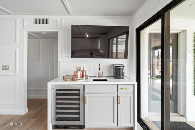 8214 E Northland Dr, Scottsdale, AZ 85251 - indoor wet bar featuring beverage cooler and light wood finished floors