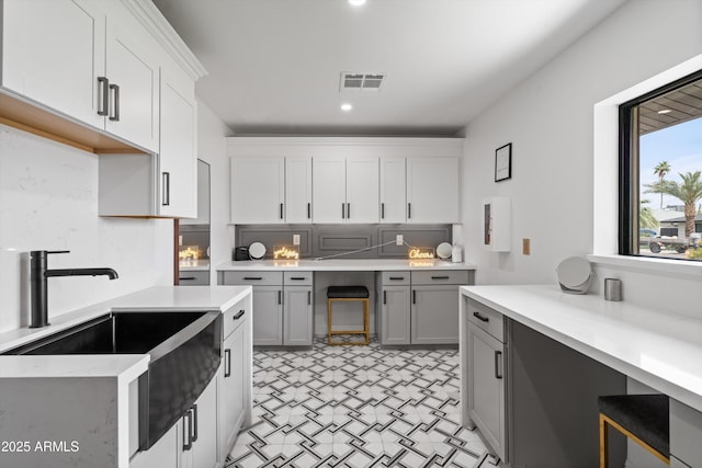 8214 E Northland Dr, Scottsdale, AZ 85251 - kitchen featuring a sink, light floors, light countertops, gray cabinets, and tasteful backsplash