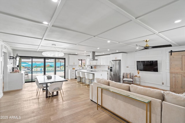 8214 E Northland Dr, Scottsdale, AZ 85251 - living room featuring recessed lighting, coffered ceiling, a barn door, light wood-style floors, and a ceiling fan