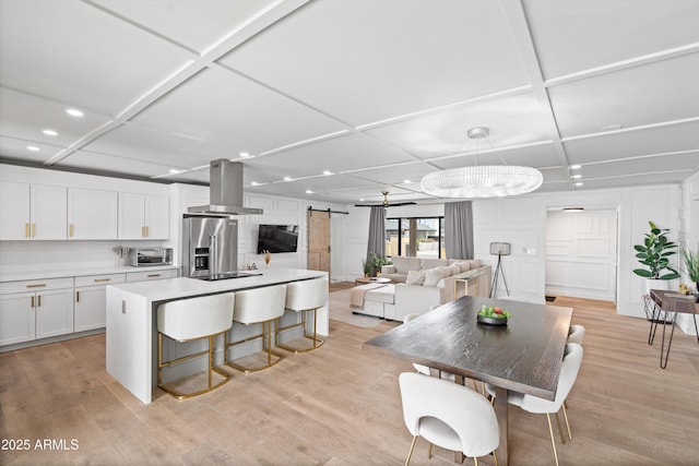 8214 E Northland Dr, Scottsdale, AZ 85251 - kitchen featuring island exhaust hood, coffered ceiling, a barn door, recessed lighting, and white cabinets