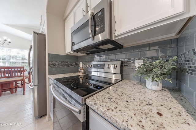 kitchen featuring light stone counters, appliances with stainless steel finishes, tasteful backsplash, and white cabinetry