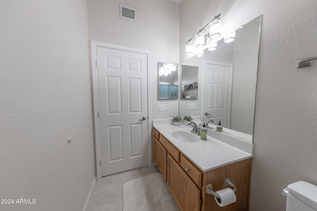 bathroom featuring tile patterned flooring, vanity, and toilet