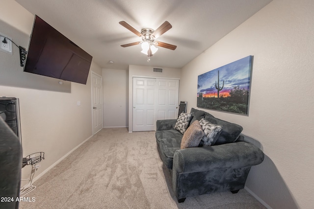 living area with ceiling fan and light colored carpet