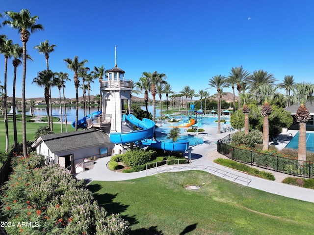 view of community with a water view, a playground, and a lawn