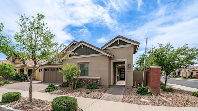 craftsman inspired home featuring driveway, a garage, stucco siding, and a tiled roof